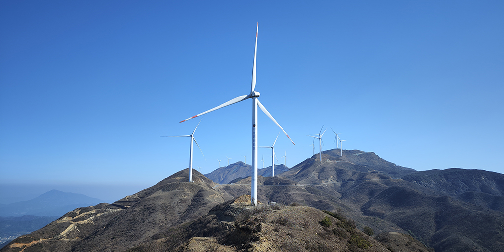 a group of wind turbines on top of a mountain
